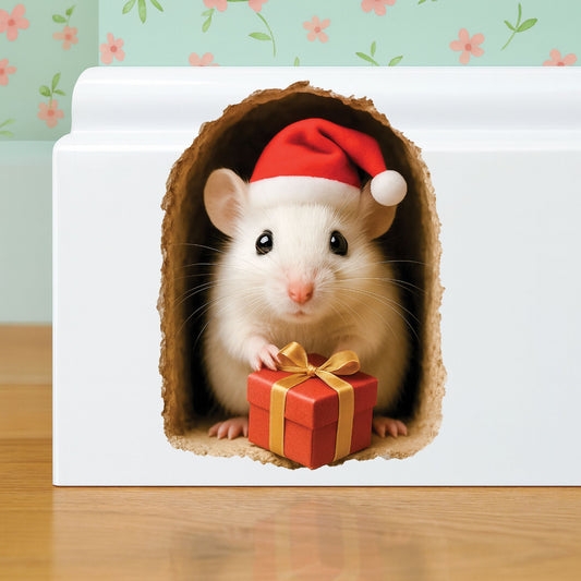 Mouse wearing a Santa hat with a gift inside a cardboard box on a wooden surface.